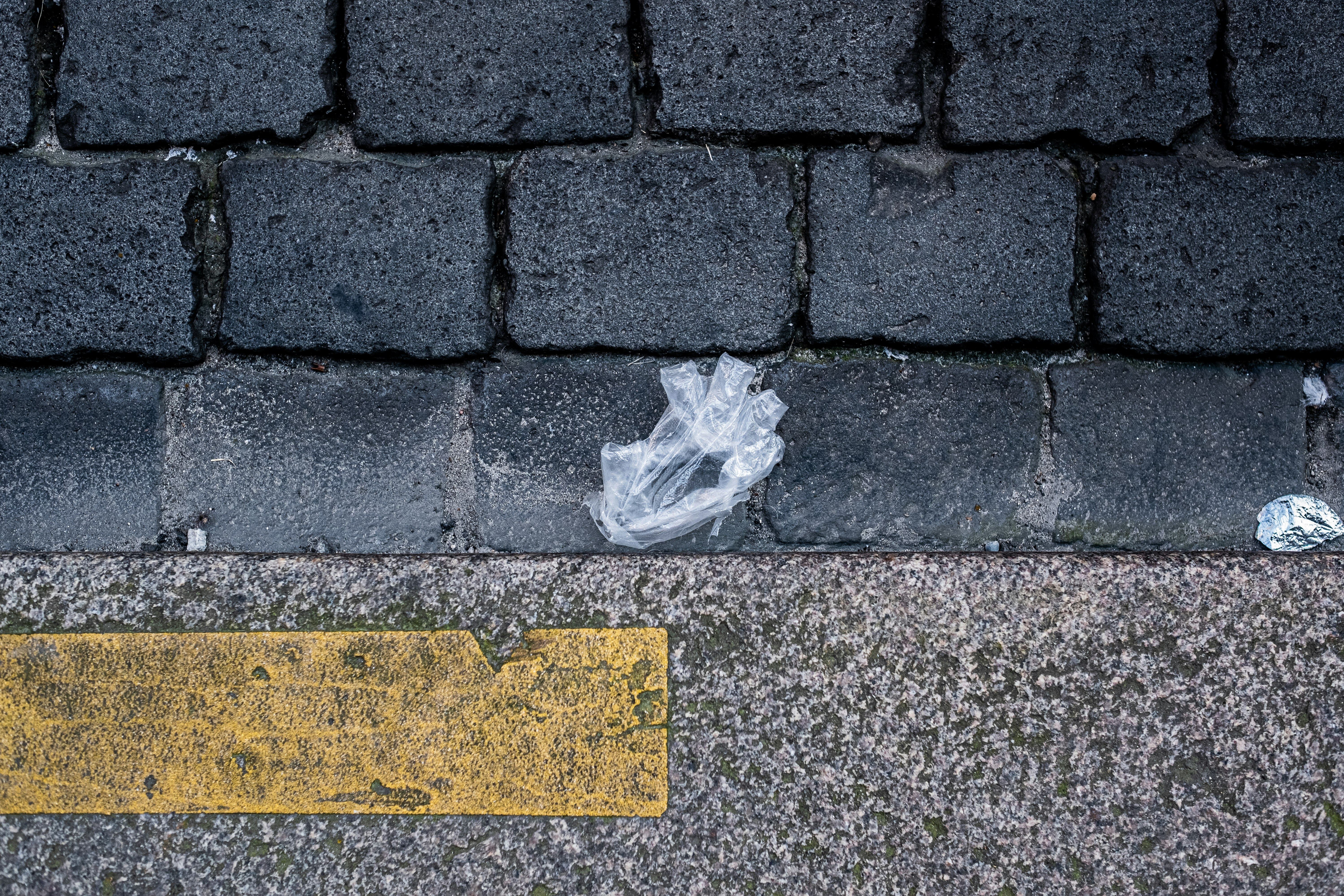clear plastic bag on gray brick floor